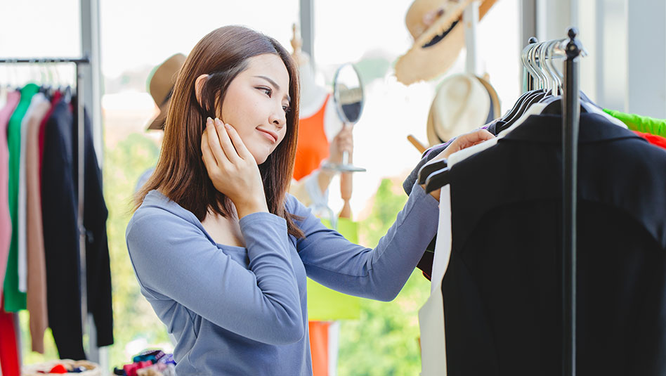 A person looking at a rack of clothes