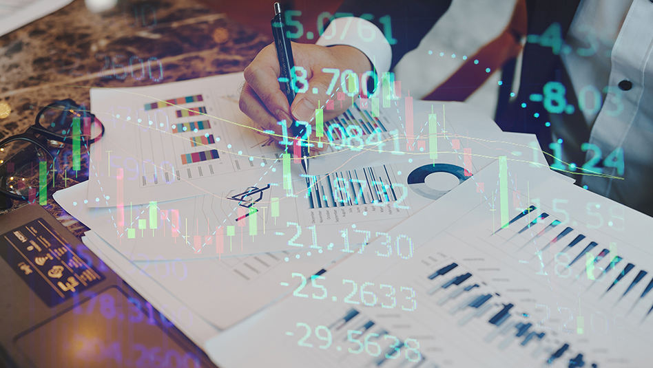 Man with a pen studying printed charts on a table.