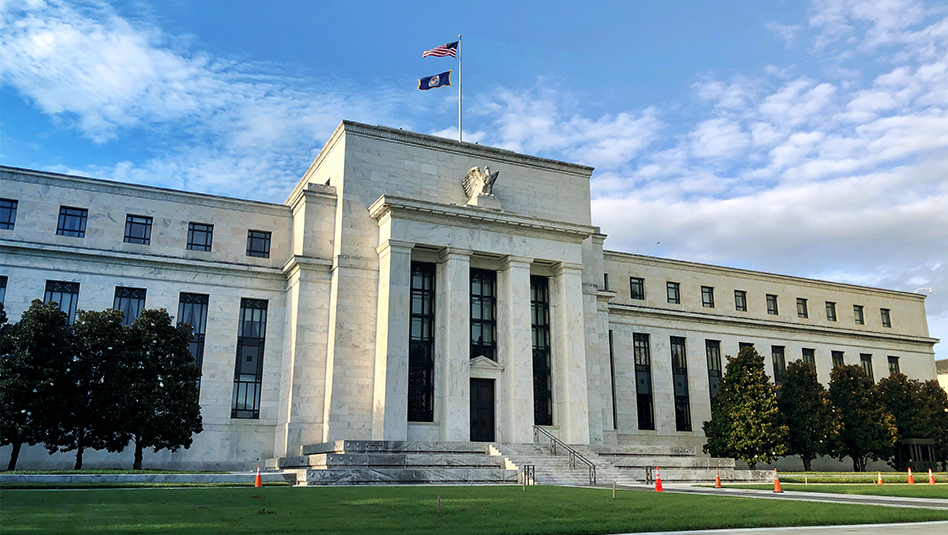 Façade of the US Federal Reserve with the flag of the United States on top.