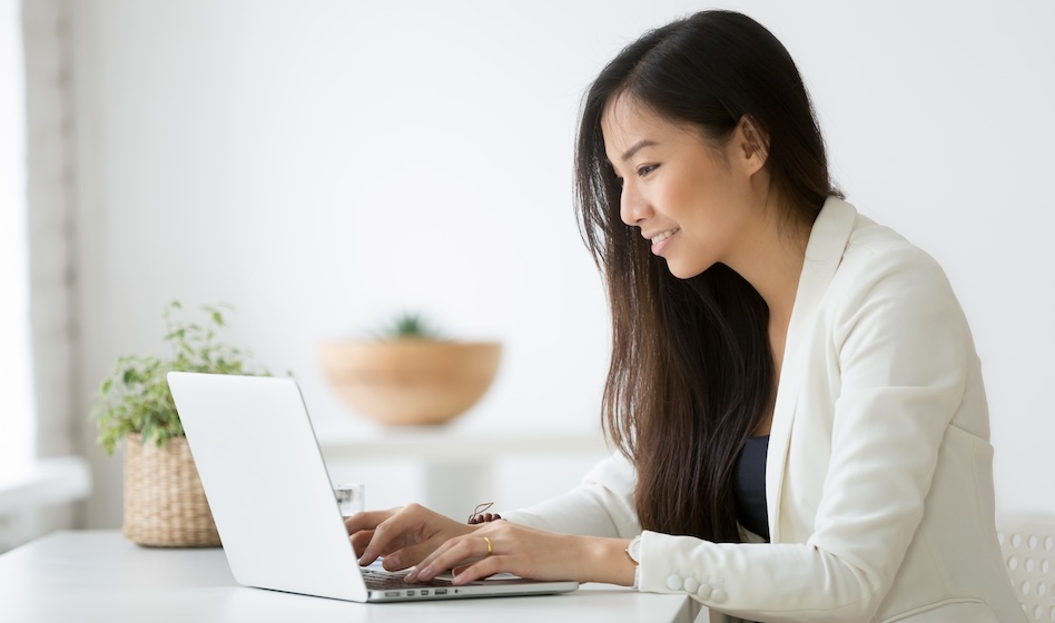 Young female professional typing on her laptop .