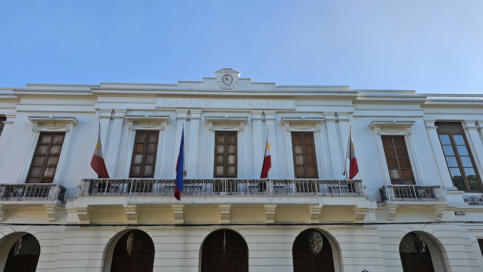 Front view of the Bureau of the Treasury with four Philippine flags.