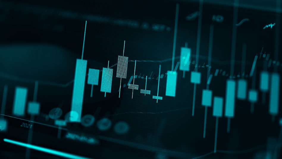 Candlestick chart against dark computer screen