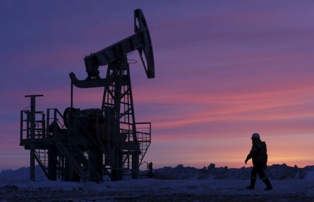 Oil prices settle up on weaker US dollar, mixed economic news