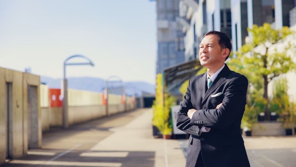 Man in business attire looking out on the horizon .