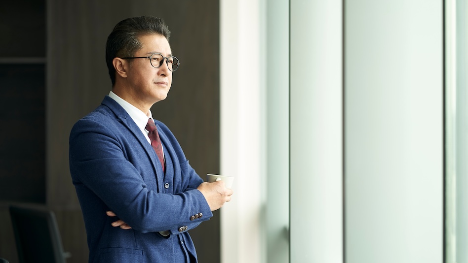 Executive holding a cup by the window